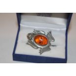 A Sterling silver and amber set brooch in the form