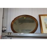 A gilt oval framed bevel edge wall mirror