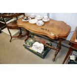 A late Victorian carved walnut table raised on str