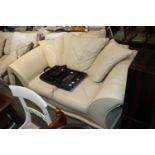 A cream upholstered two seater settee