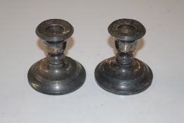 A pair of silver dwarf candlesticks with weighted