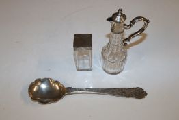 A white metal serving spoon and a silver topped ja