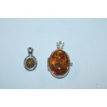 A Sterling silver and amber locket and similar pen