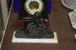 A bronzed figure depicting child reading raised on