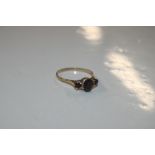 A 9ct gold ring set with three garnet coloured sto