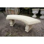 A curved bench raised on plinth legs