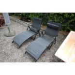 A pair of folding metal garden loungers