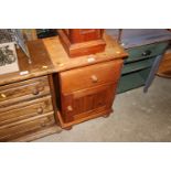 A stripped pine bedside cupboard