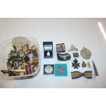 A box of mixed military badges, buttons, and coins