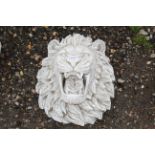 A cast concrete plaque in the form of a lions head