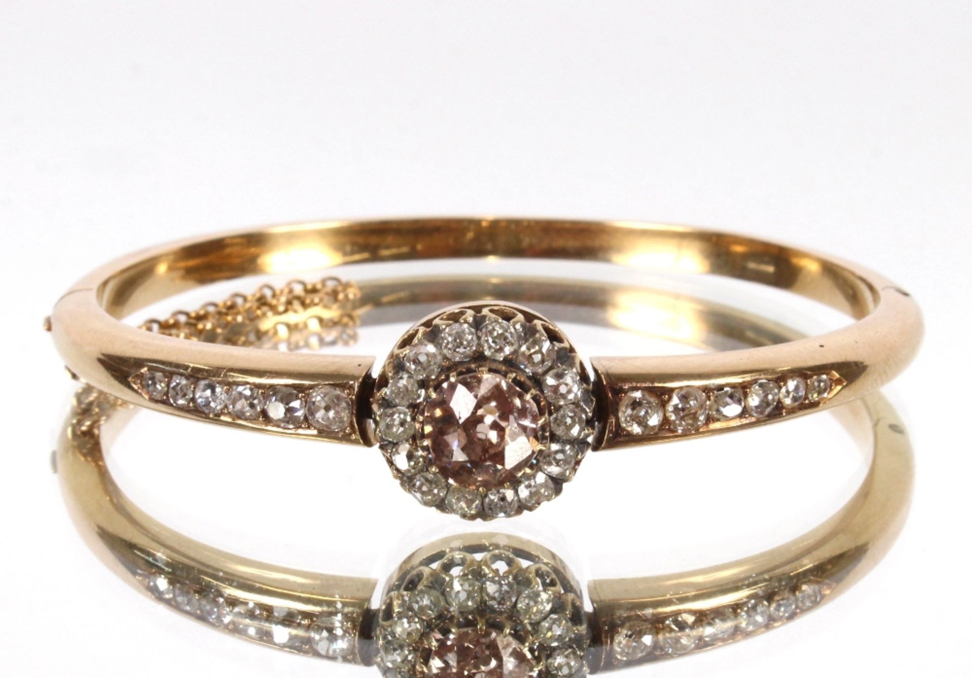 A diamond bangle, the yellow metal hinged bangle, set with central fancy coloured diamond approx.