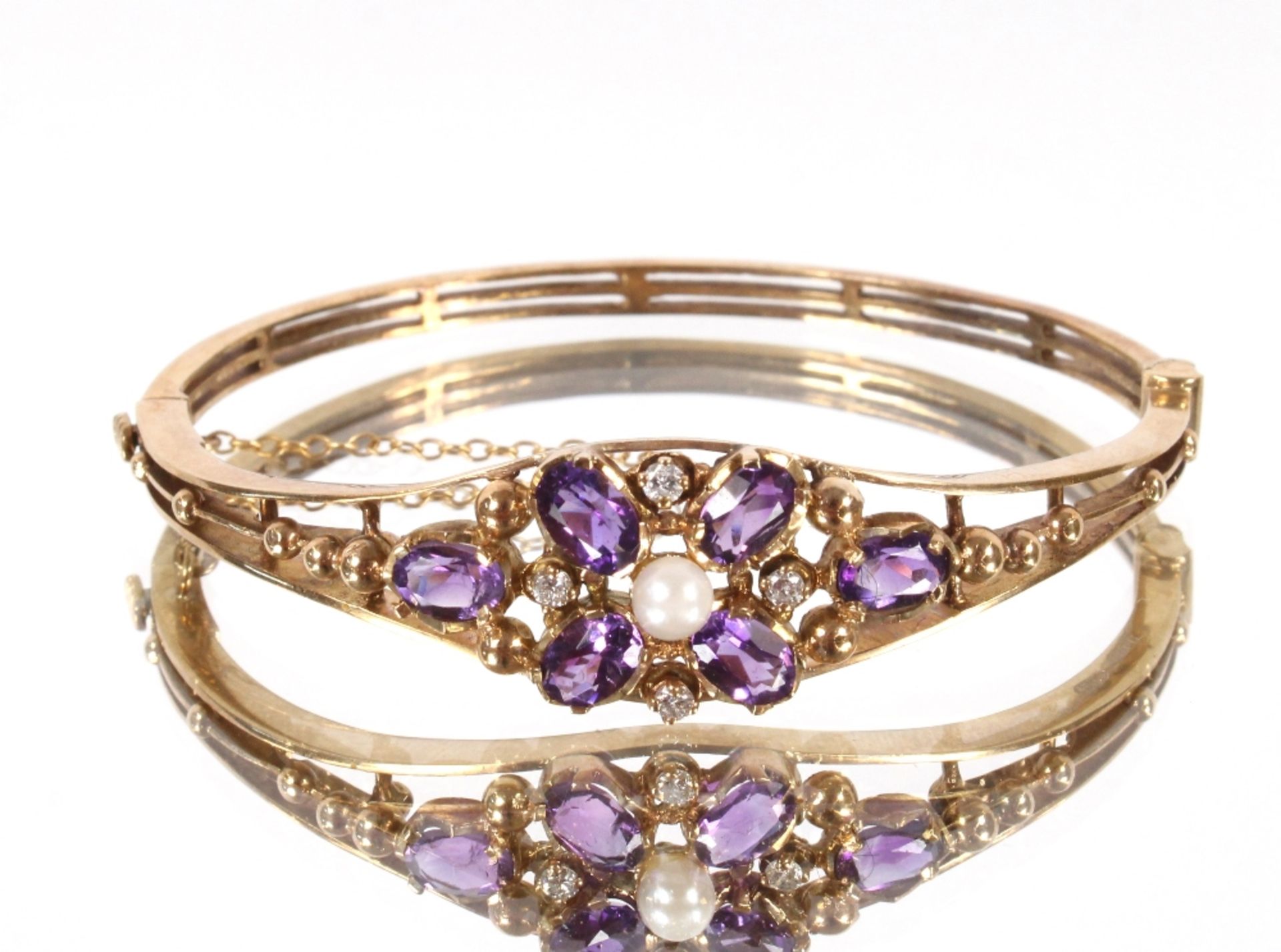 A 9ct gold diamond and amethyst bangle, the centra