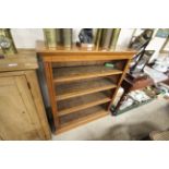 A late Victorian golden oak open fronted bookcase