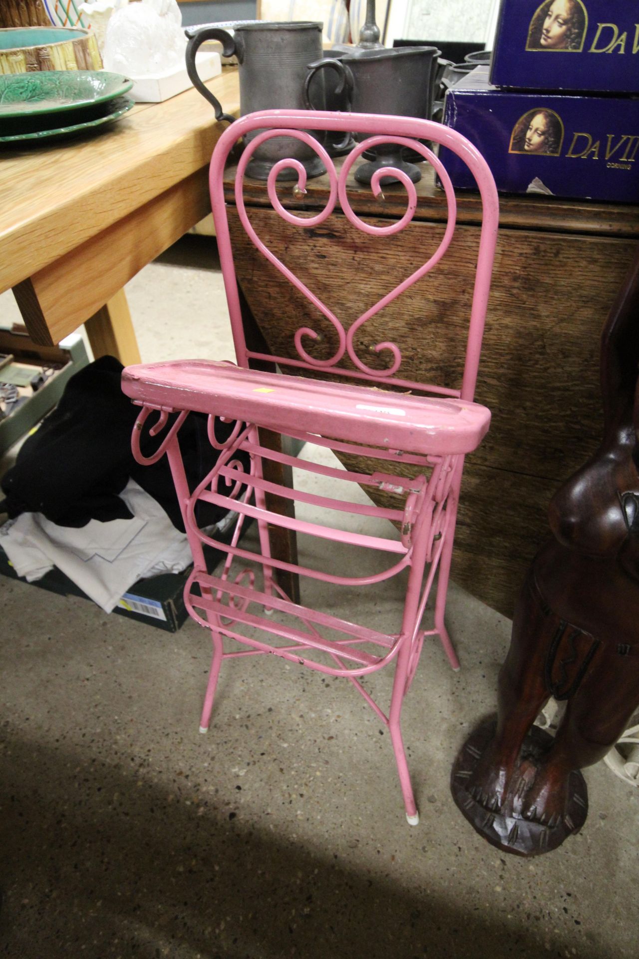 A wrought metal pink painted child's high chair
