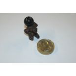 A small bronze figure of a crouching beast carrying a globe; and a circular brass plaque