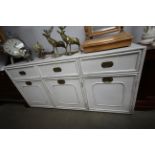 A white painted sideboard, fitted three drawers and cupboard below