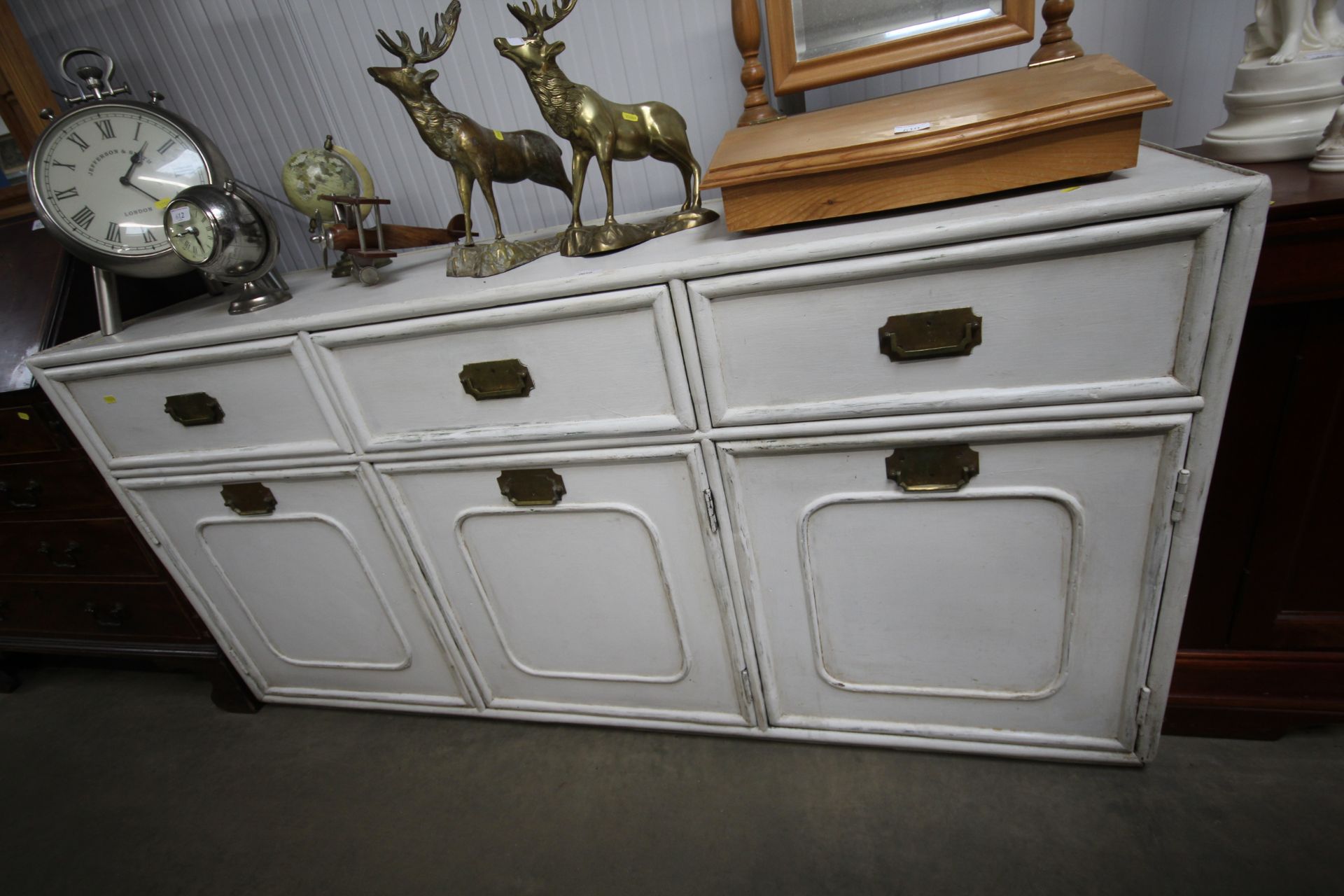 A white painted sideboard, fitted three drawers and cupboard below