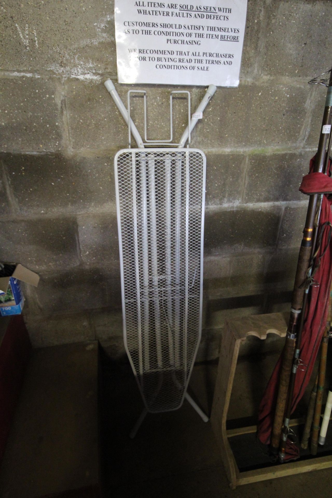 A metal ironing board lacking cover