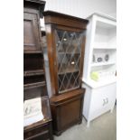 An oak and leaded glazed corner cabinet