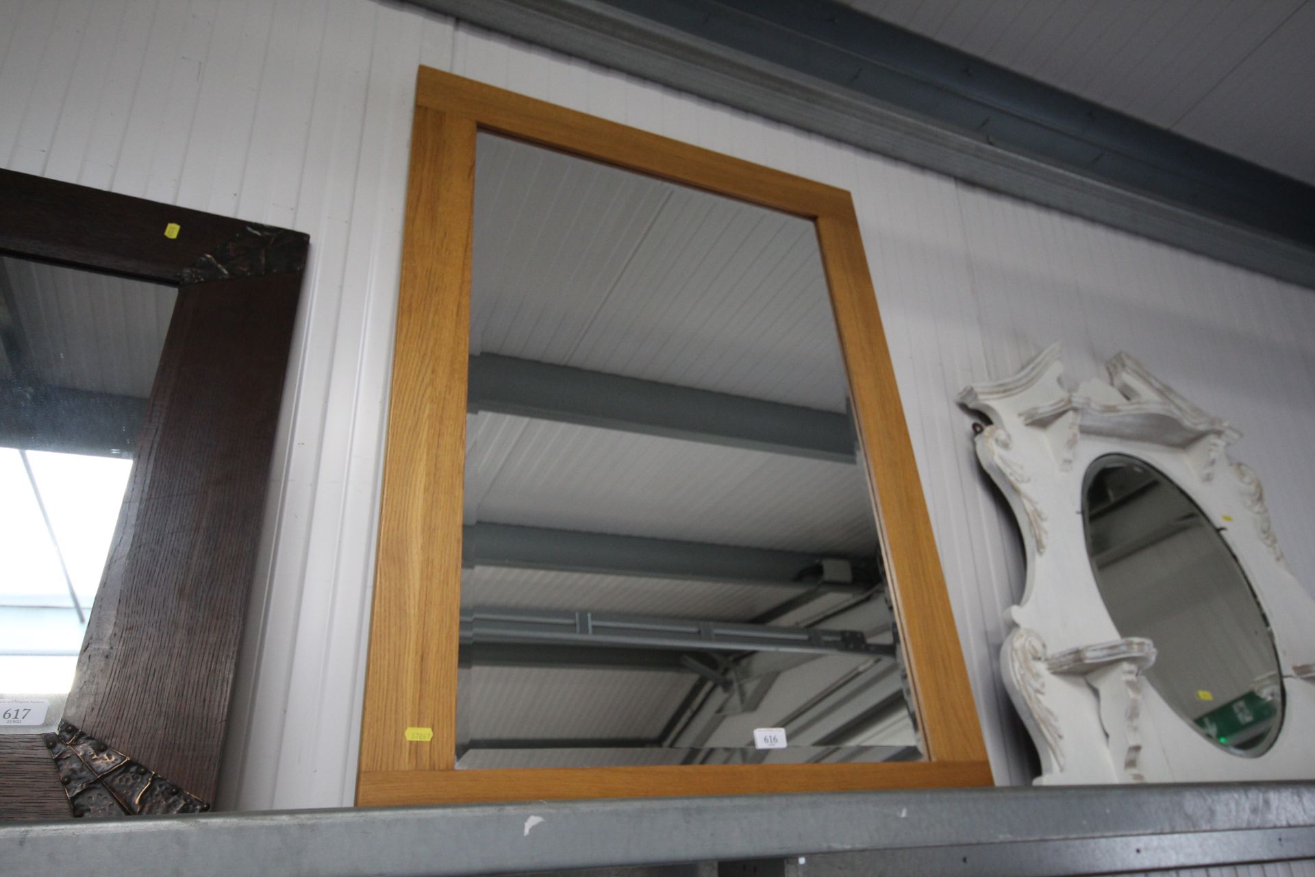 A light oak and bevel edged oblong wall mirror