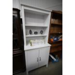 A white painted bookcase raised on cupboard base