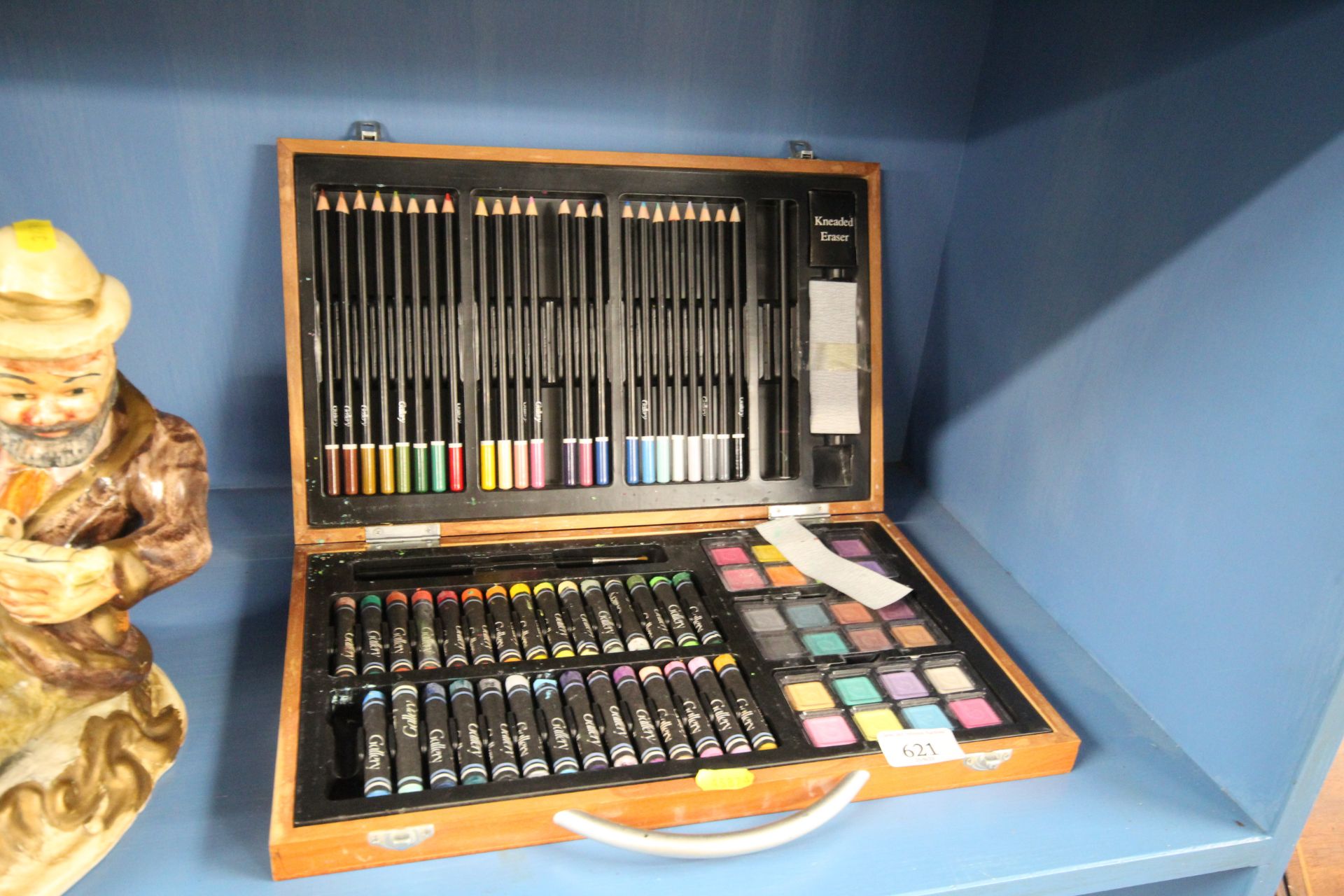 An artists box and contents of pencils, pastels an