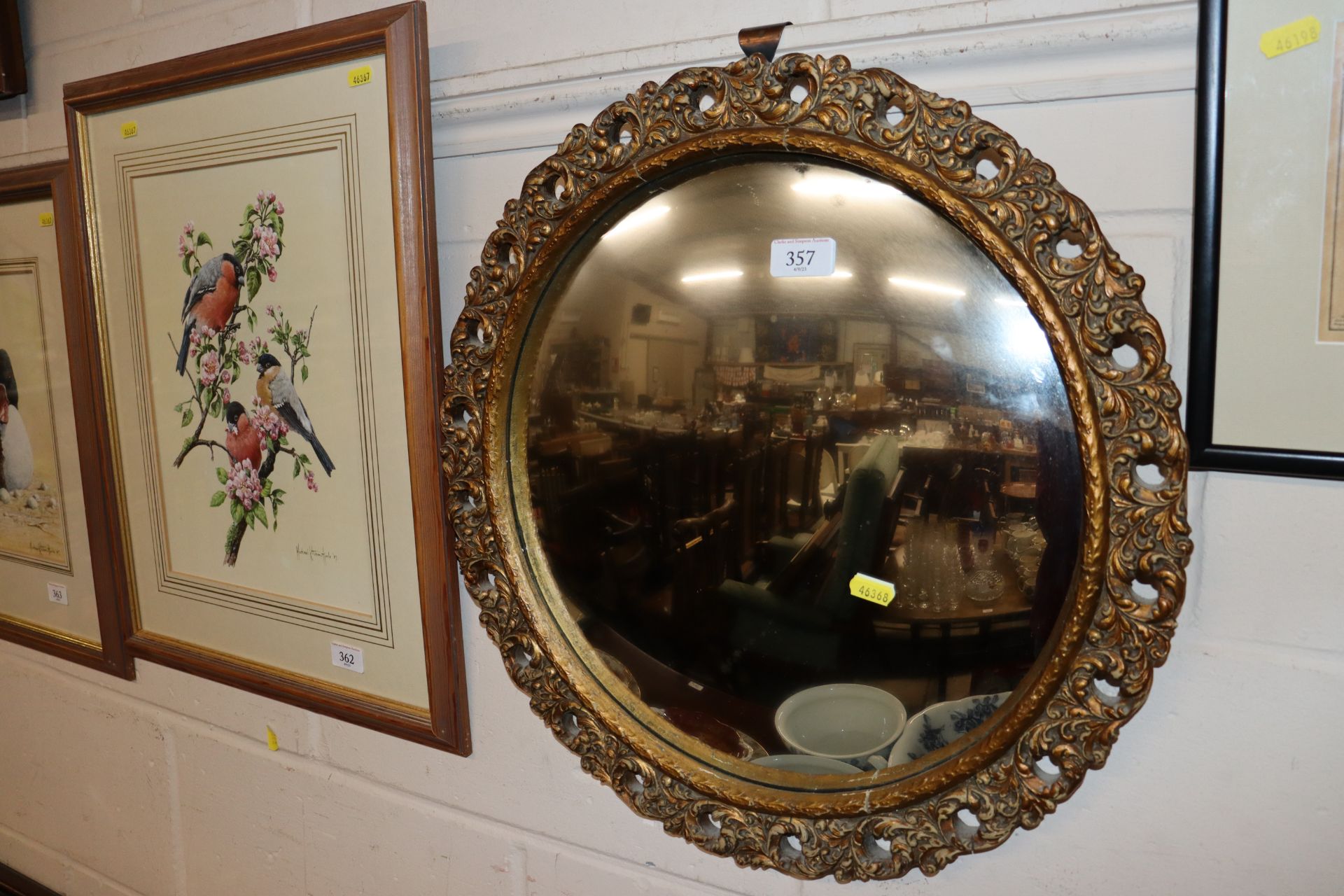 A circular gilt framed convex wall mirror