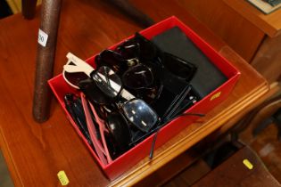 A box of various reading glasses and sunglasses