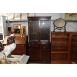 A reproduction mahogany display cabinet on cupboard