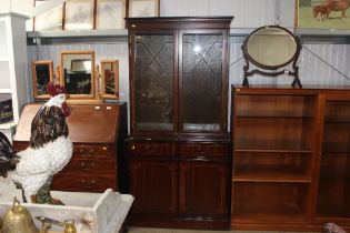 A reproduction mahogany display cabinet on cupboard