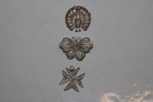 A silver filigree work peacock brooch, butterfly b