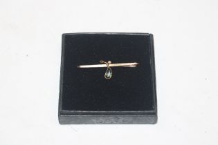 A 15ct gold bar brooch, set with peridot coloured