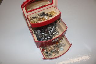A red jewellery box and contents of costume jewell