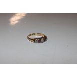 An 18ct gold ring set with three diamonds and colo