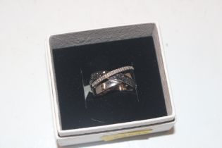 A modernist Sterling silver cross over ring, ring