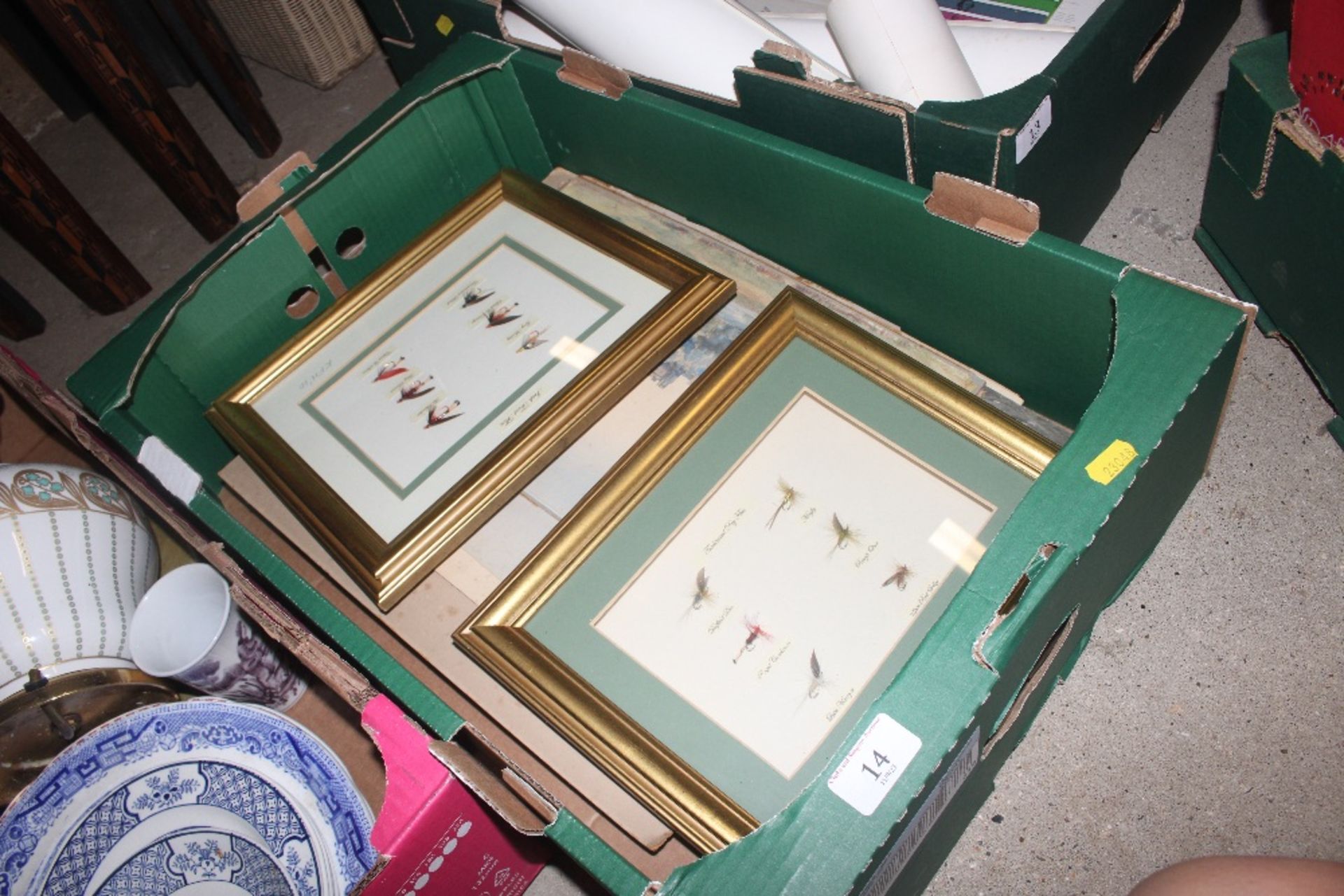 A box of various pictures, framed fly fishing lure