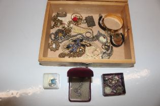 A wooden box and contents of costume jewellery inc