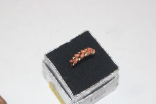 A yellow metal and coral set ring