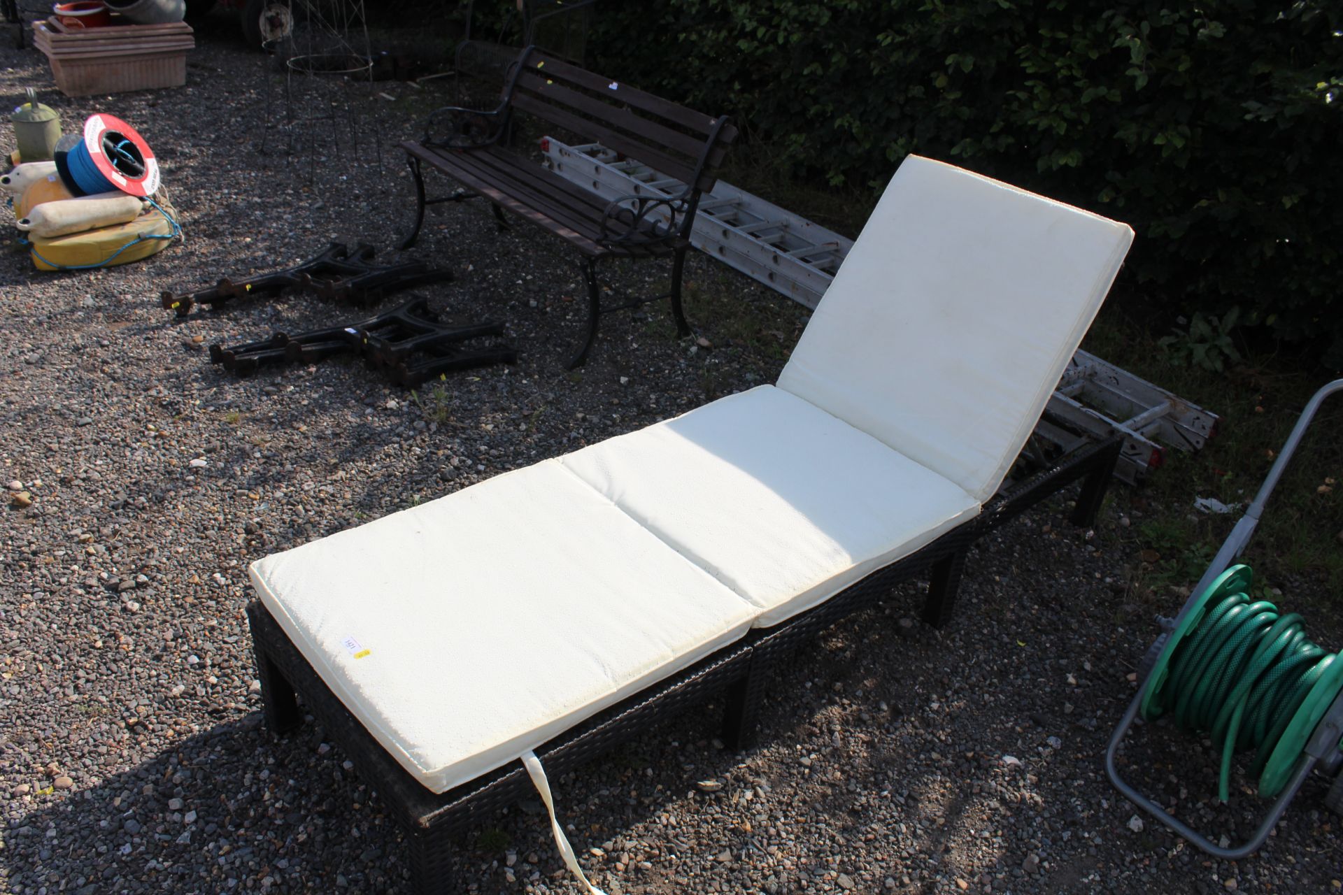 A rattan style sun lounger with cushions