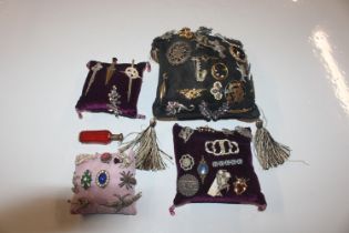 Four cushions decorated with various brooches and