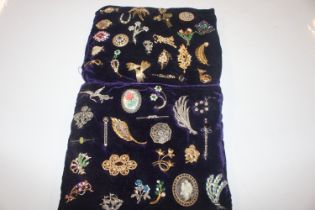 Two cushions decorated with brooches and costume b