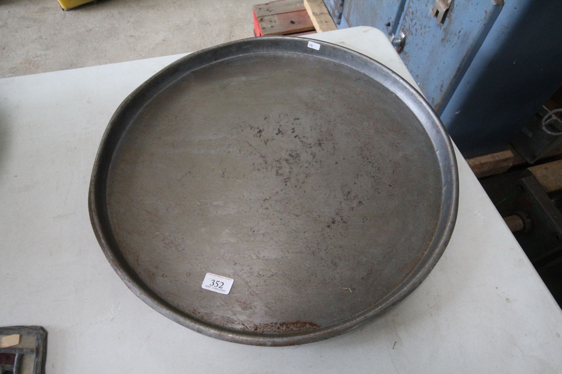 A circular metal ware shallow tray