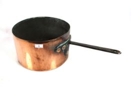 A large copper saucepan with iron handle