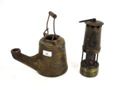 A cast iron Wells Unbreakable oil lamp and a miners lamp