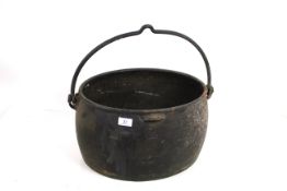 A vintage iron cooking pot with swing handle