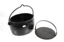 An antique cast iron cauldron and a skillet