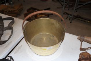 A vintage brass jam pan with iron loop handle