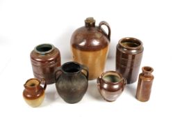 Six brown glazed earthenware pots, jugs and a flag