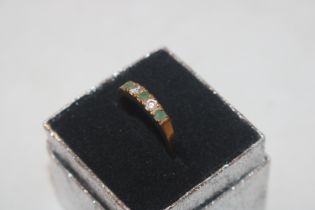 A yellow metal ring set with green and white stone