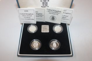 A case of four silver proof £1 coins and ingot wit